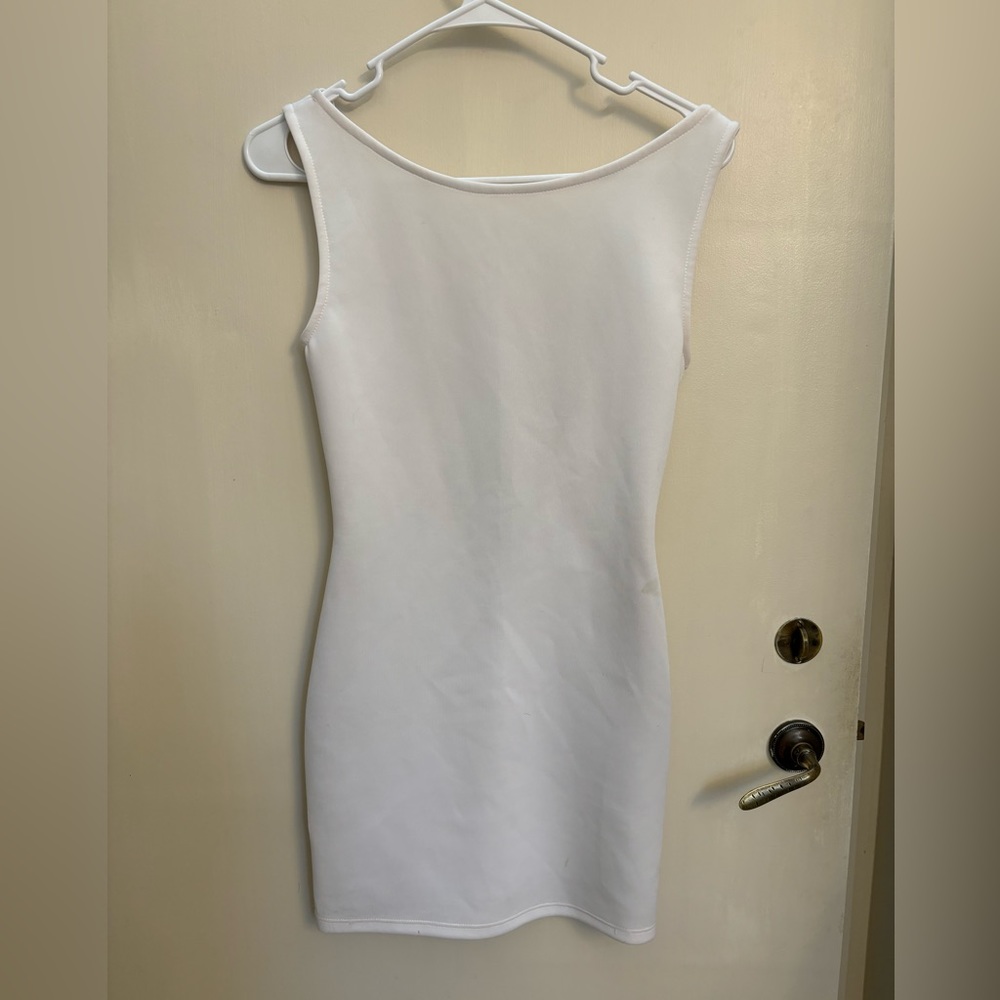 White mini dress with low back and chain detail.